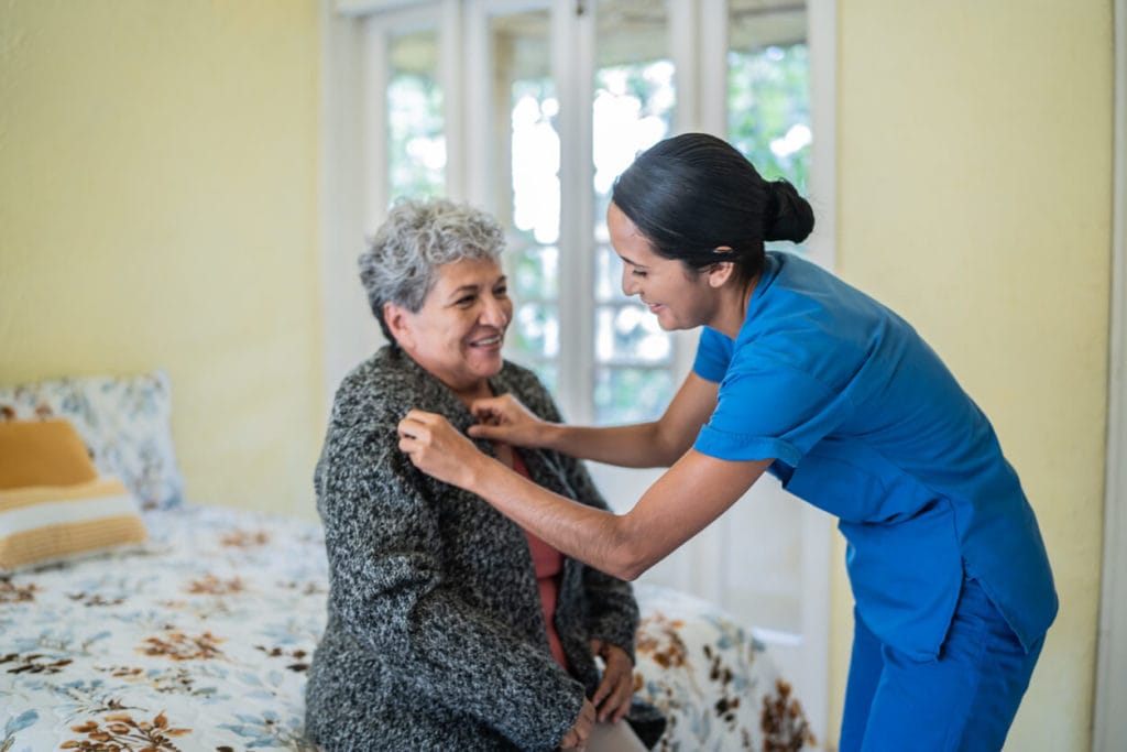 senior woman dress shirt in bedroom at nursing home