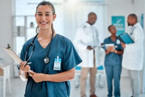 emale doctor holding a clipboard working at a hospital with colleagues in medical center