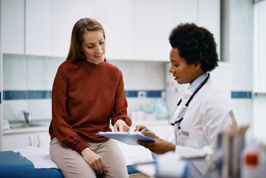 Happy woman going through her medical data during doctor visit