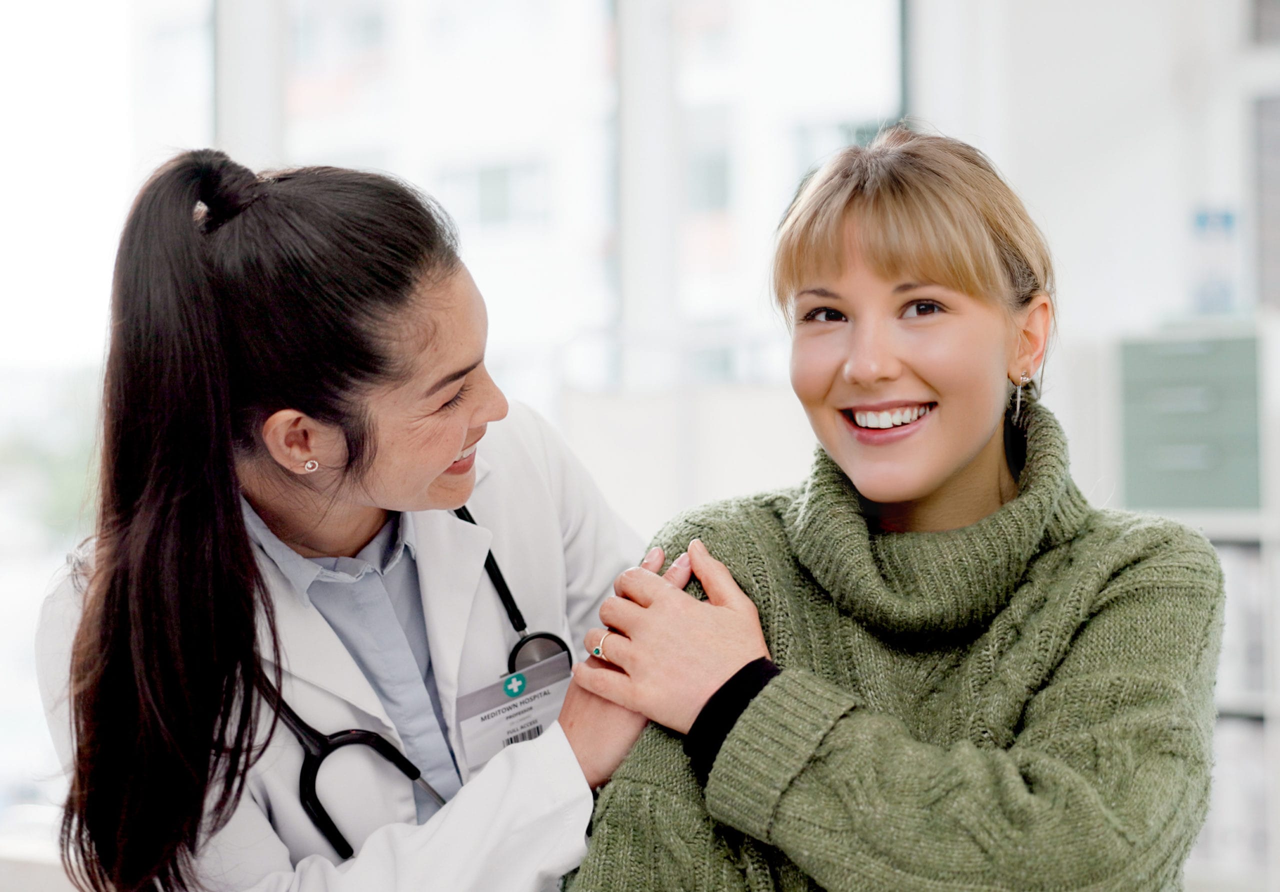 primary care doctor smiling at and talking to senior woman