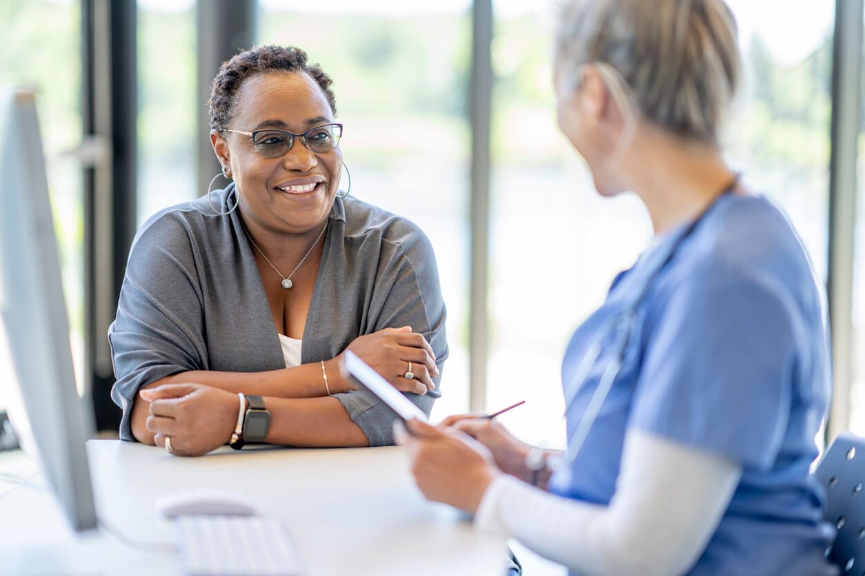 A women's primary care doctor consulting a middle-aged woman, providing support for menopause symptoms.