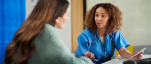 A female primary care doctor consulting with her female patient during a medical appointment.