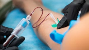 A nurse is taking blood samples from a patient for a blood test in the hospital.