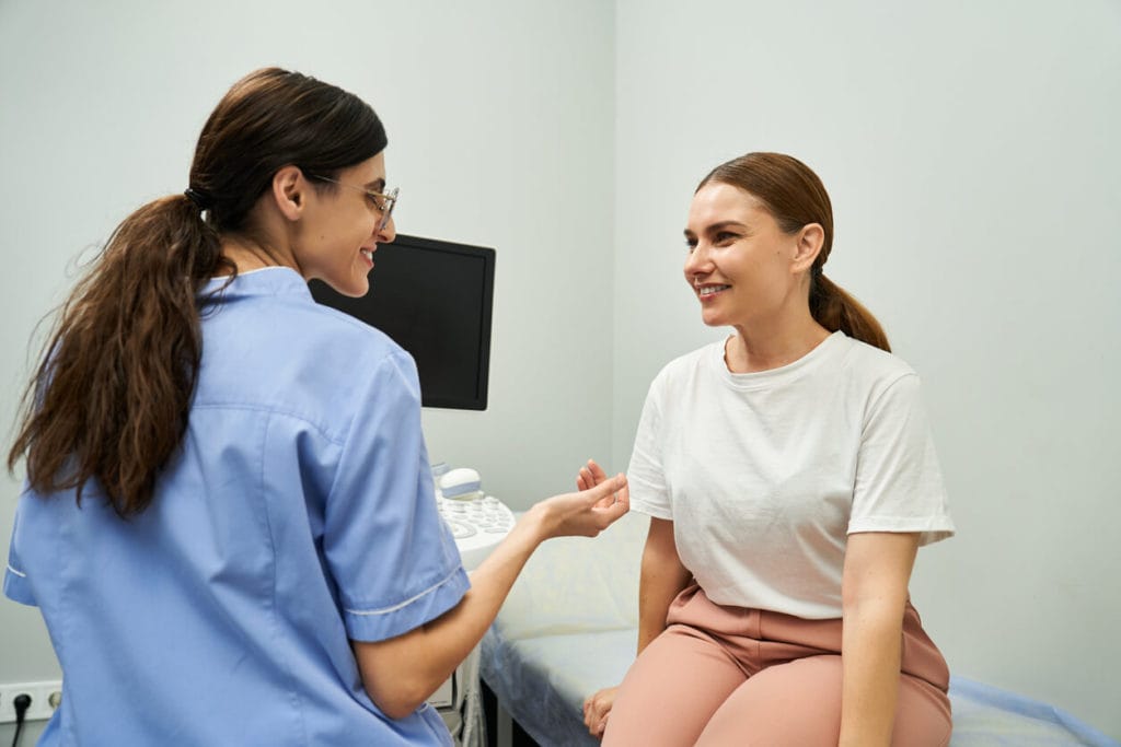 Women's Primary Care Doctors consult with patients in a modern clinic, enhancing female health.
